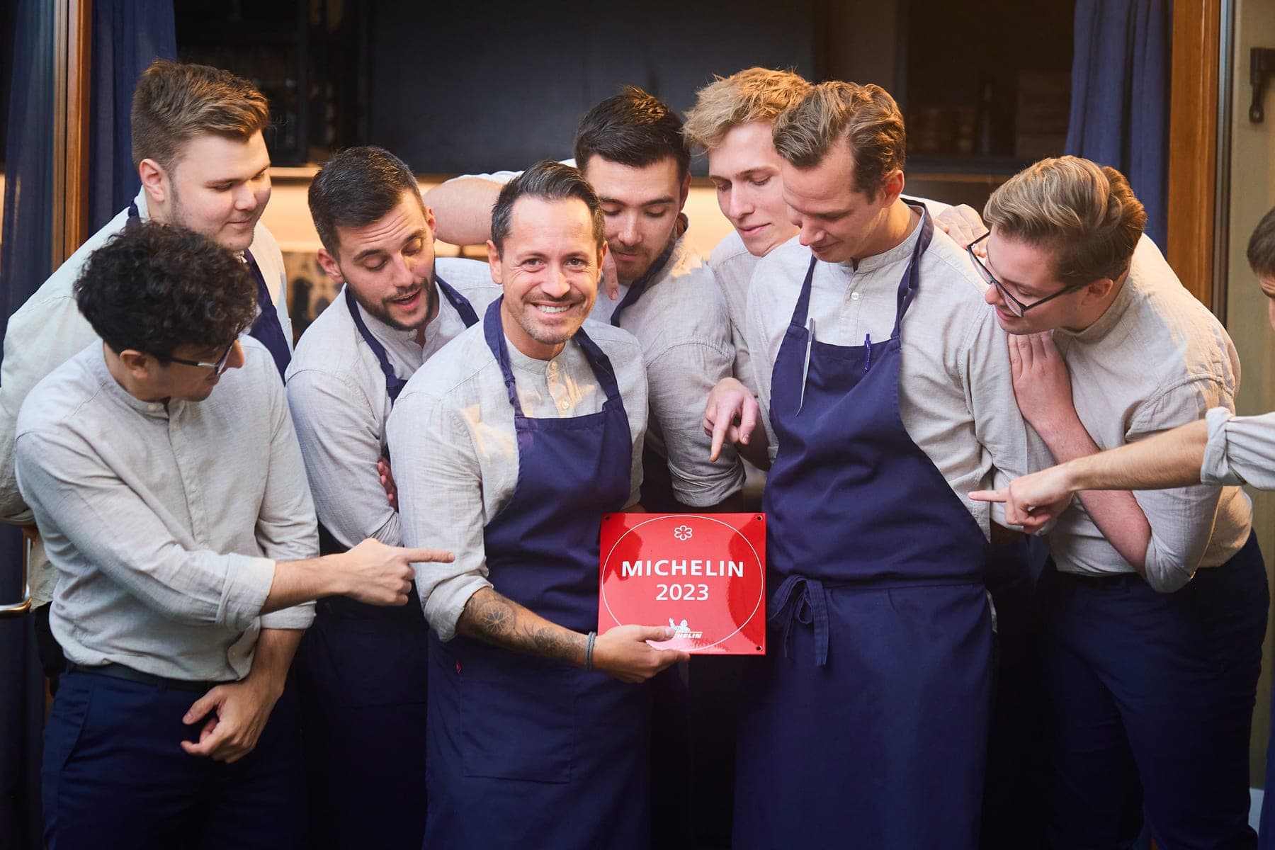 Restaurantteam som holder fram en Michelin-plakett